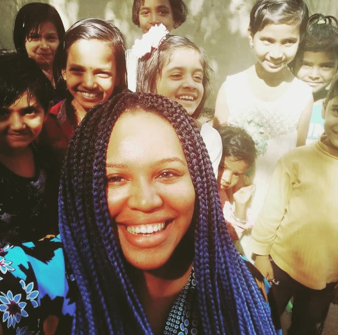 Renada smiling with a group of children