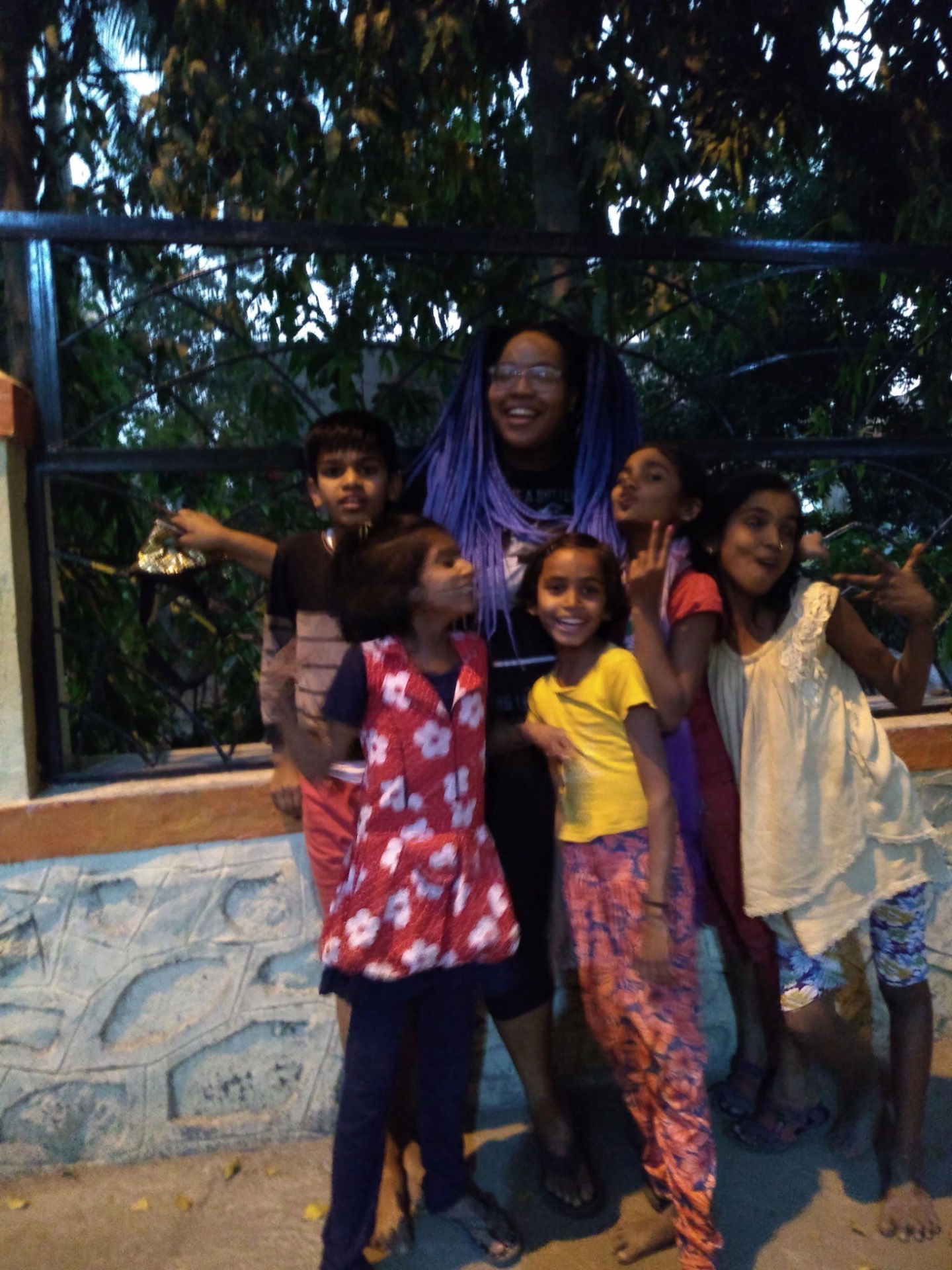 Renada laughing with a group of children outdoors